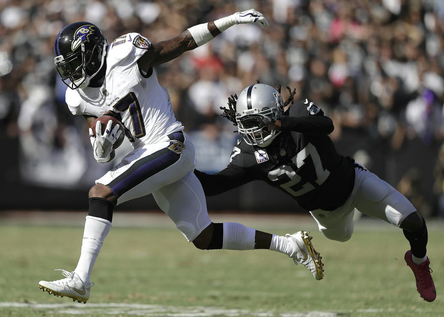 Baltimore Ravens wide receiver Mike Wallace (17) runs past Oakland Raiders free safety Reggie Nelson (27) during the second half of an NFL football game in Oakland, Calif., Sunday, Oct. 8, 2017. (AP Photo/Marcio Jose Sanchez)