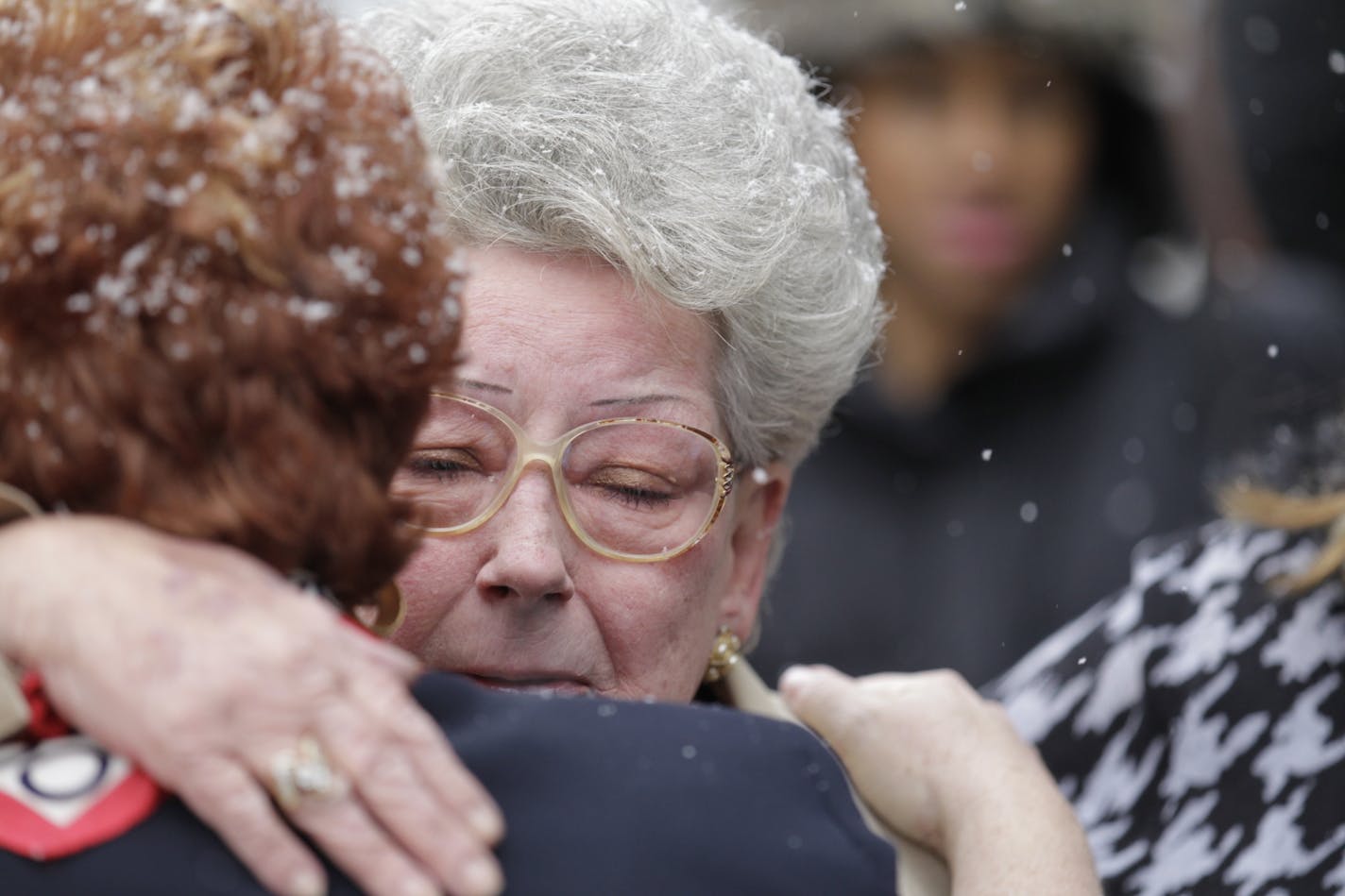 Beverly Hecker, Denny Hecker's sister (facing camera), hugs one of her brother's attorneys after Hecker was sentenced to 10 years in federal prison.