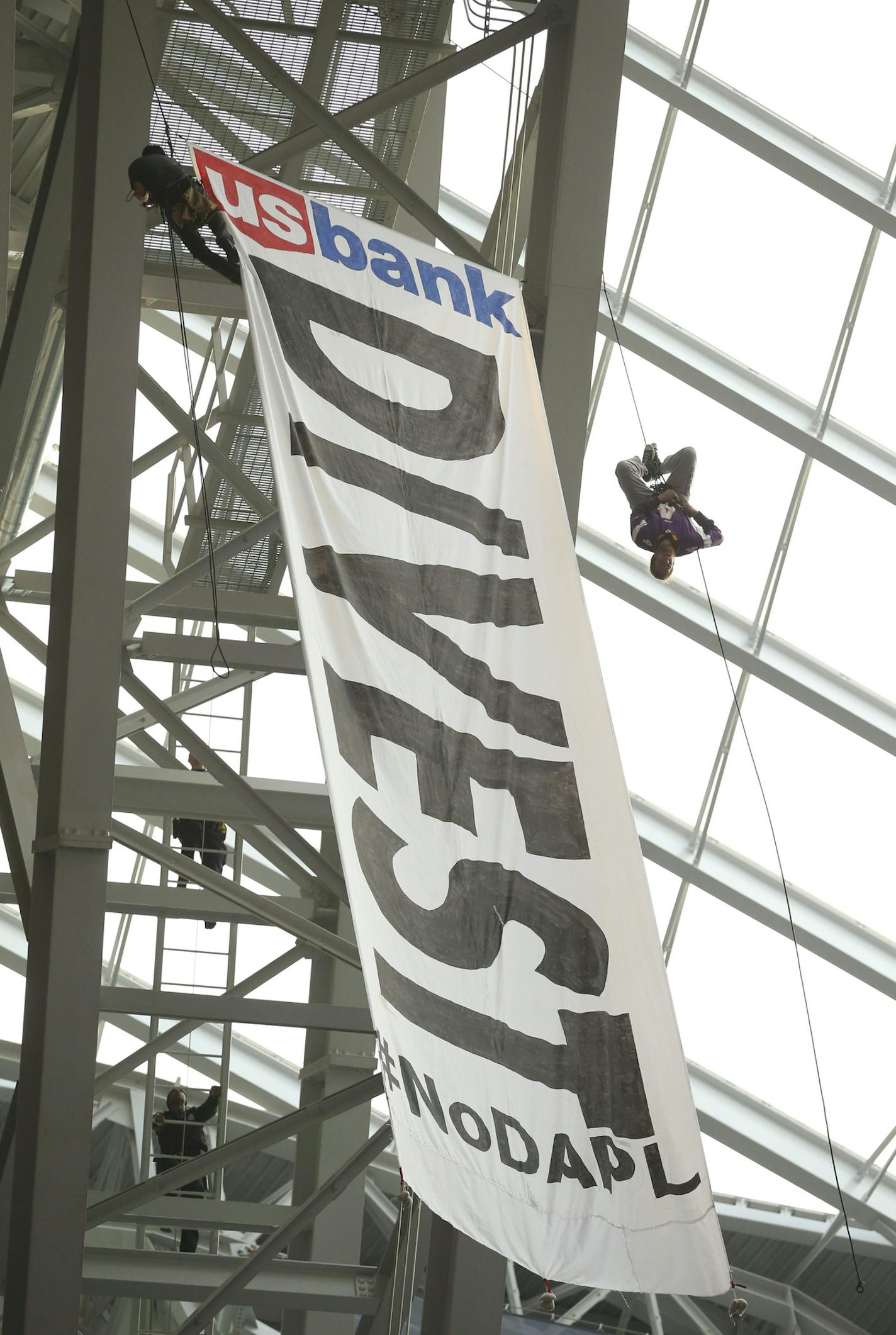 Protestors hung a banner from the catwalk of U.S. Bank Stadium calling for U.S. Bank to divest it's interests in the controversial pipeline in the Dakotas. ] JEFF WHEELER &#xef; jeff.wheeler@startribune.com The MInnesota Vikings faced the Chicago Bears in their final game of the NFL season Sunday afternoon, January 1, 2017 at U.S. Bank Stadium in Minneapolis.