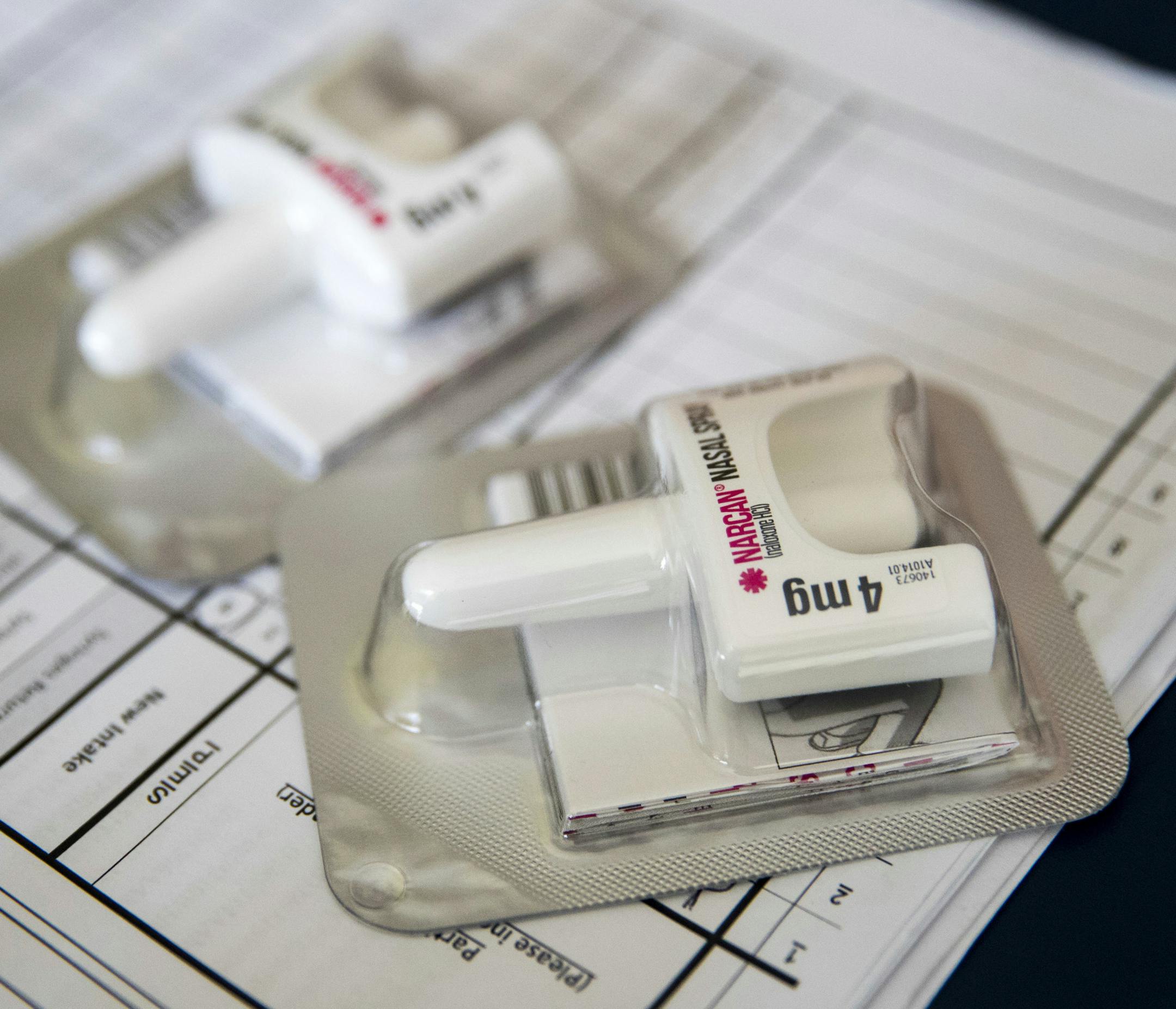 FILE - In this Tuesday, July 3, 2018 file photo, a Narcan nasal device which delivers naloxone lies on a counter as a health educator gives instructions on how to administer it in the Brooklyn borough of New York. On Wednesday, Dec. 19, 2018, the U.S. government told doctors to consider prescribing the overdose antidote naloxone to many more patients who take opioid painkillers. (AP Photo/Mary Altaffer)