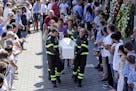 Firefighters carry the coffin of 9-year-old Giulia Rinaldo outside the gymnasium where a funeral service for some of the victims of the earthquake tha