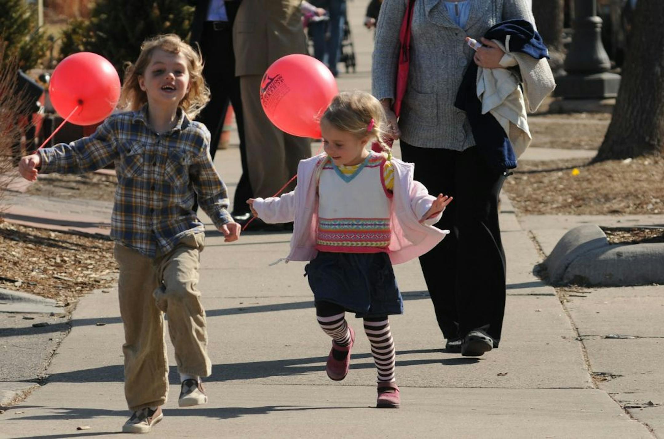 With temperatures possibilly reaching 70's today it was a good day to to out in the sunshine. 5 year old Hale Ronning of Minneapolis and his 3 year old sister Pela ran down the sidewalk on Grand Ave in St Paul, Minn. with their new red balloons. They both had just visited the Red Ballon Bookshop.
