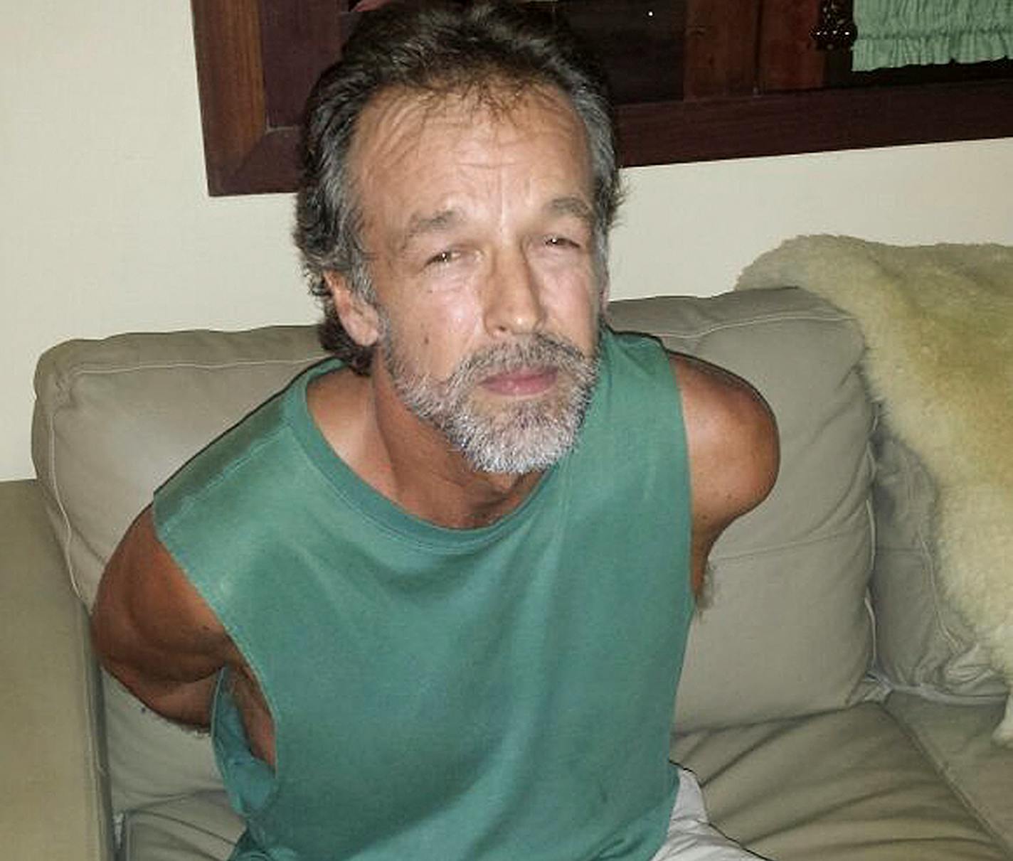 In this photo released by Rio Grande do Norte State Security secretary, American sect leader Victor Arden Barnard sits in a police station after being detained at Pipa beach, in the Northeastern state of Rio Grande do Norte, Brazil, Friday, Feb. 27, 2015. Barnard is facing 59 counts of criminal sexual conduct related to two young women who said they were abused for nearly a decade at his secluded River Road Fellowship in Minnesota.