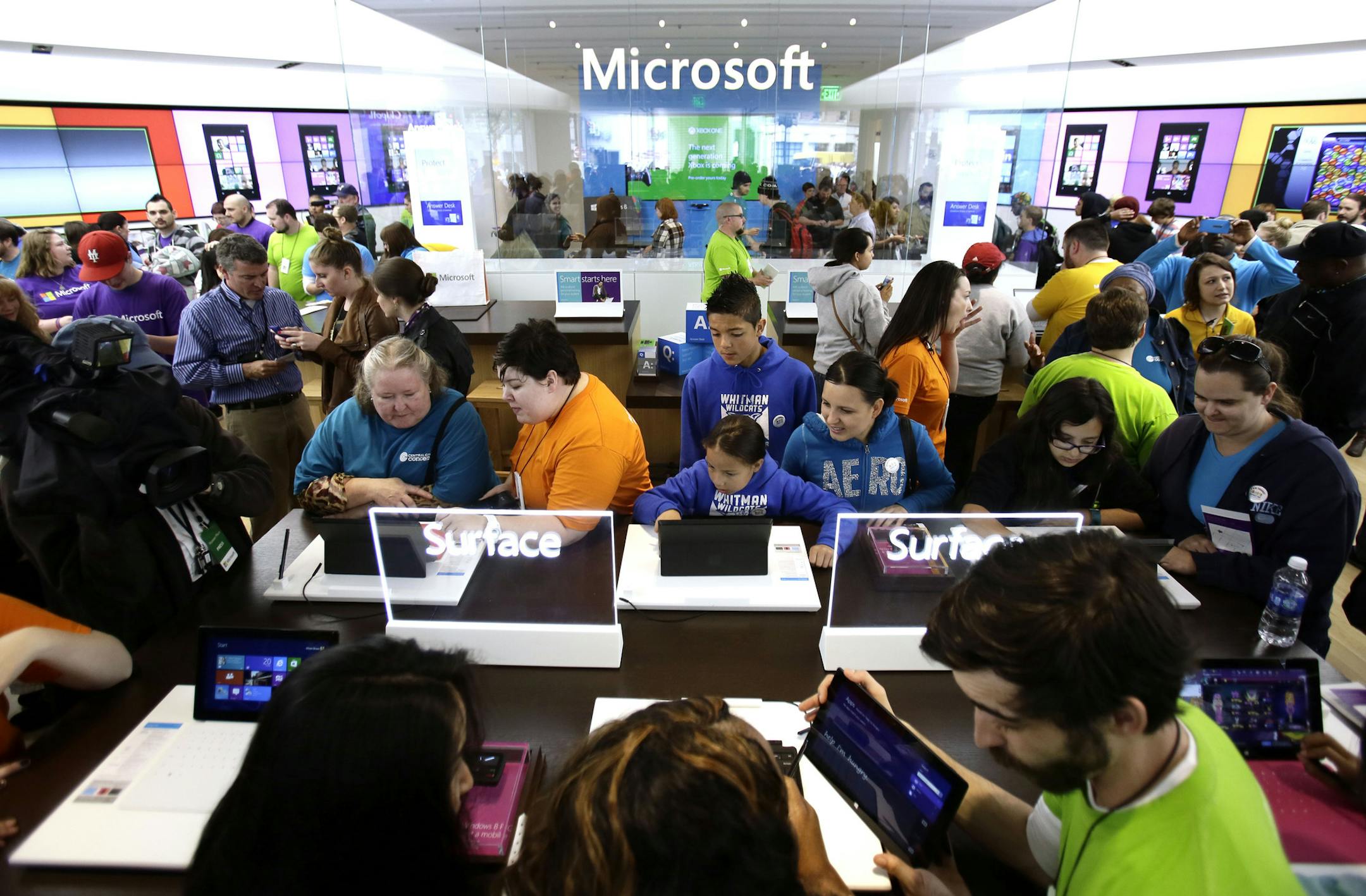 In this Thursday, June 20, 2013, photo, people crowd the aisles during the grand opening of a Microsoft retail store in downtown Portland, Ore. Microsoft Corp. reports quarterly financial results after the market closes on July, 18, 2013. (AP Photo/Don Ryan) ORG XMIT: MIN2013082118162400
