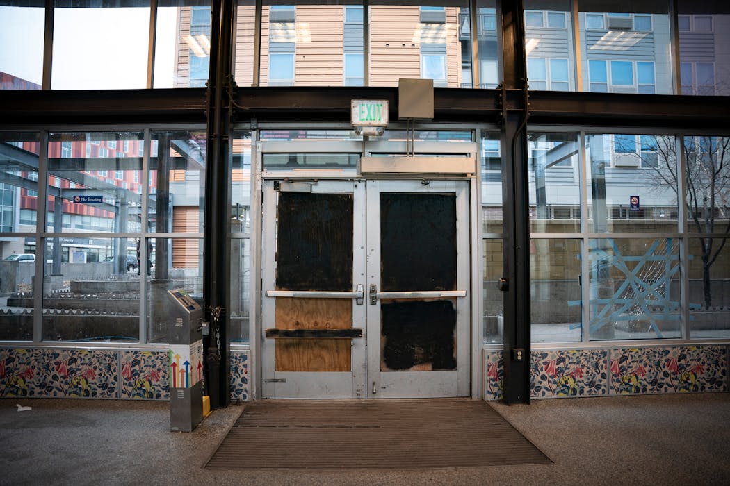 An entrance to the Lake Street/Midtown light rail station is covered with plywood and spray paint in Minneapolis.