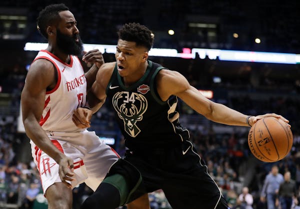 Milwaukee Bucks' Giannis Antetokounmpo tries to drive past Houston Rockets' James Harden during the second half of an NBA basketball game Wednesday, M