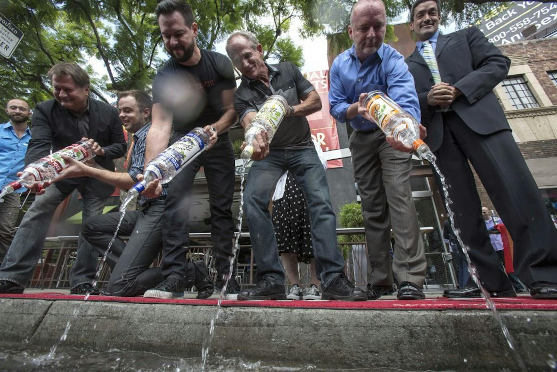 From left to right, Michael Niemeyer, Matthew Ervin, Alfredo Diaz, Richard Grossi, Rodney Scott and council member John Duran empty Russian vodka bottles into a gutter during a news conference on Thursday, Aug. 1, 2013 in West Hollywood, Calif. Bar owners joined with West Hollywood city officials to announce a boycott of Russian vodkas as part of a protest that has stretched across the county in opposition to anti-gay laws recently signed by Russian President Vladimir Putin.