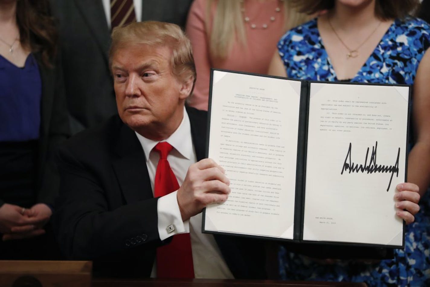 President Donald Trump held up an executive order he signed Thursday requiring colleges to certify that their policies support free speech as a condition of receiving federal research grants.