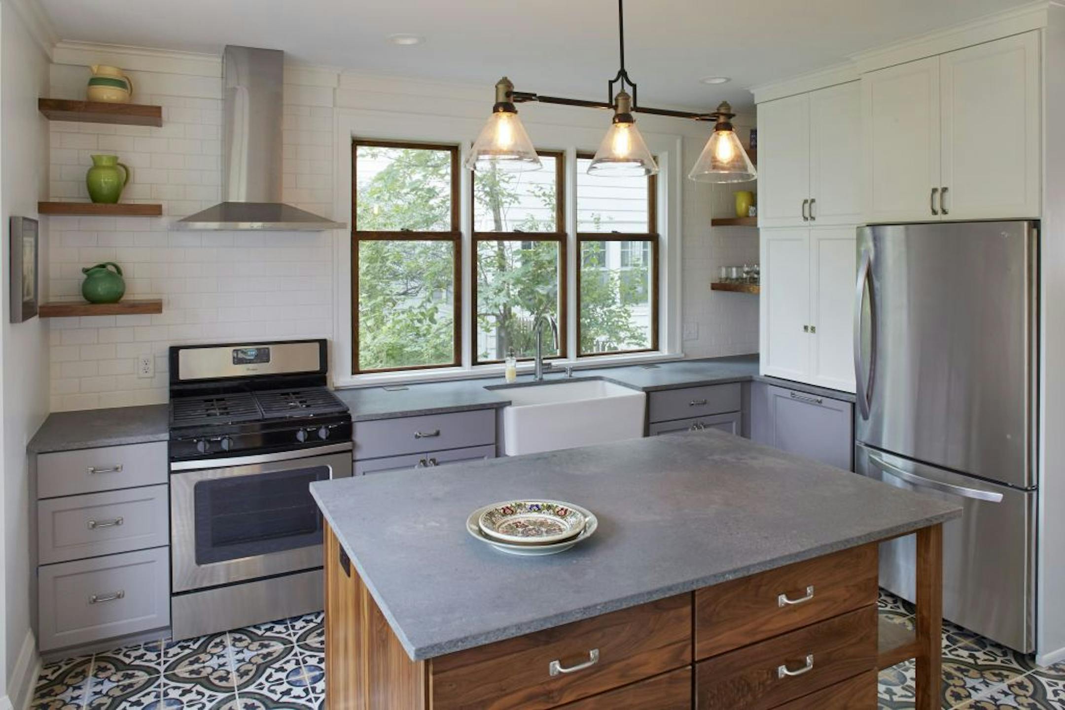 The new kitchen's concrete-looking quartz counters, open walnut shelves and Dutch floor tiles.