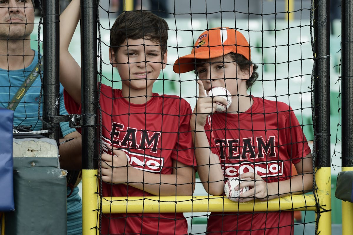 Boys wait for an opportunity to ask for autographs from the players before the final match of a two-game Mayor League Series between the Minnesota Twi