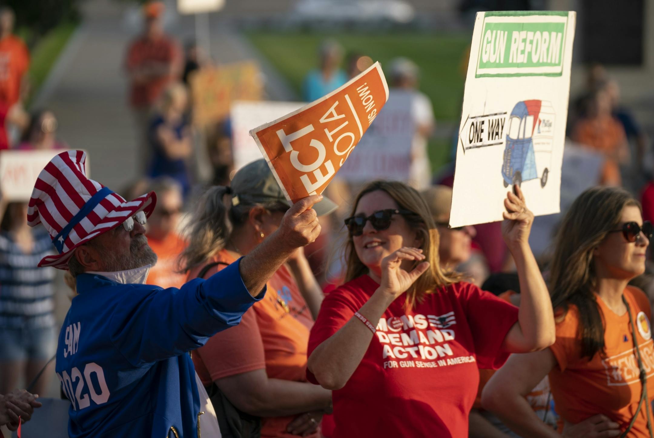 Attendees held signs up while listening to speakers at the rally. It was organized in the wake of the mass shootings in Texas and Ohio.
