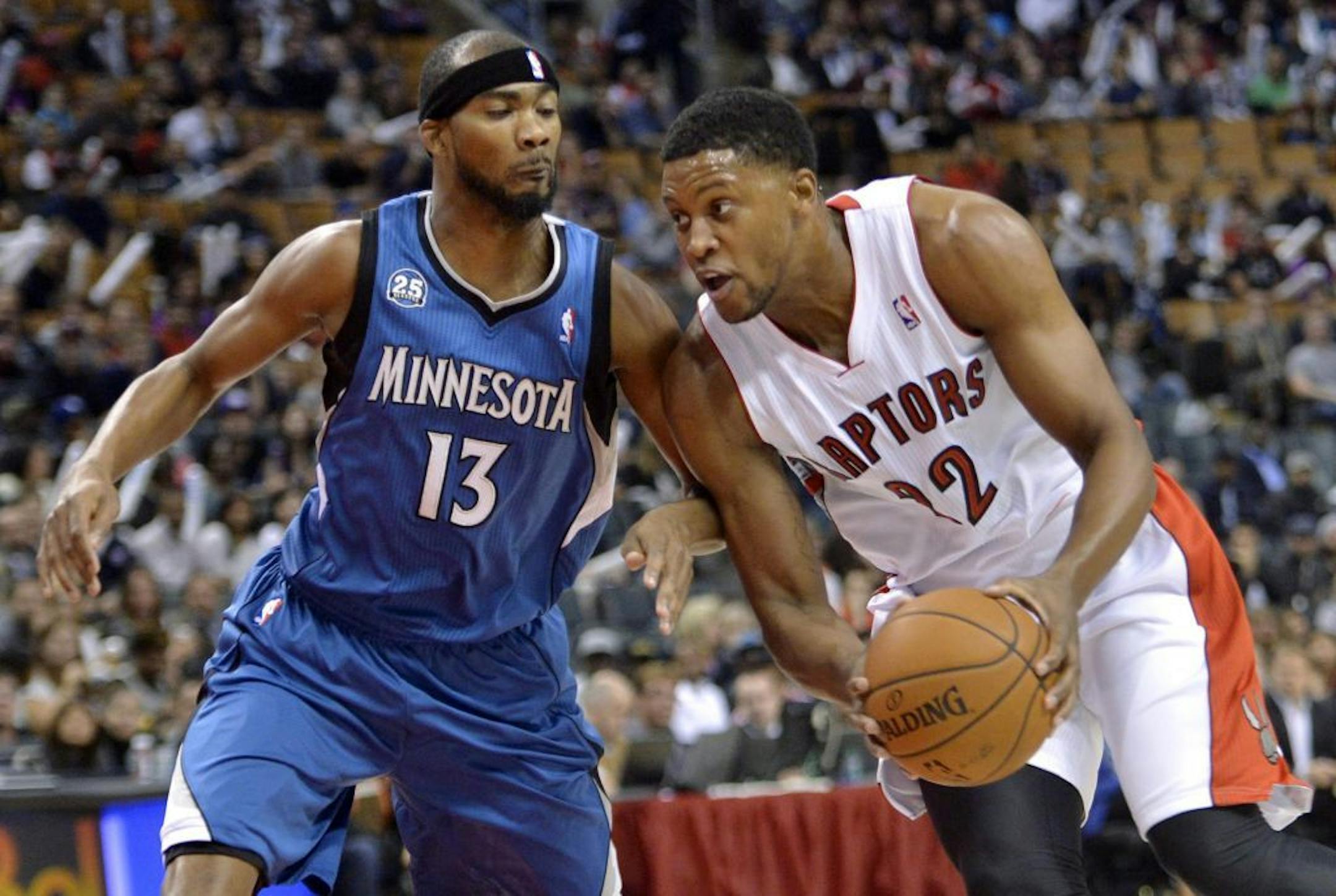 Toronto Raptors' Rudy Gay, right, moves the ball up court as Minnesota Timberwolves' Corey Brewer defends during the first half of an NBA preseason basketball game in Toronto on Wednesday, Oct. 9, 2013.