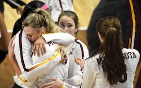 Minnesota setter Samantha Seliger-Swenson (13) was comforted by teammates as she hugged middle blocker Taylor Morgan (12) following their team's 3-1 l