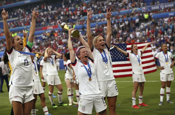 Megan Rapinoe, center, holds the trophy as she celebrates with teammates after they defeated the Netherlands 2-0 in the Women's World Cup final.
