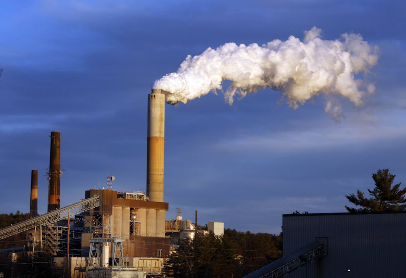 FILE - In this Jan. 20, 2015 file photo, a plume of steam billows from the coal-fired Merrimack Station in Bow, N.H. President Barack Obama on Monday, Aug. 3, 2015, will unveil the final version of his unprecedented regulations clamping down on carbon dioxide emissions from existing U.S. power plants. The Obama administration first proposed the rule last year. Opponents plan to sue immediately to stop the rule's implementation. (AP Photo/Jim Cole, File)