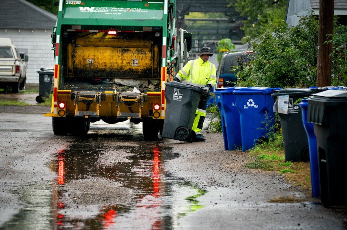 Waste Management worker Daniel Westerhaus collected trash from the alleys of the Snelling Hamline neighborhood of St. Paul's yellow zone on the first day of organized trash collection.