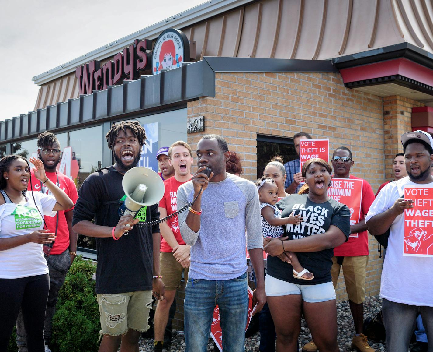 Backers of the $15 minimum wage charter amendment held a press conference/rally following a judge's decision to order the charter amendment to be put on the ballot in November. It was held in front of Wendy's on West Broadway Ave to show support for many fast food workers, especially in North Minneapolis, who are working for the minimum wage. ] GLEN STUBBE * gstubbe@startribune.com Tuesday, August 23, 2016 Holding the microphone and leading the rally are Rod Adams and Mike Griffin of NOC.