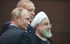 Russian President Vladimir Putin, left, Turkish President Recep Tayyip Erdogan and Iranian President Hassan Rouhani, right, pose for a picture after a
