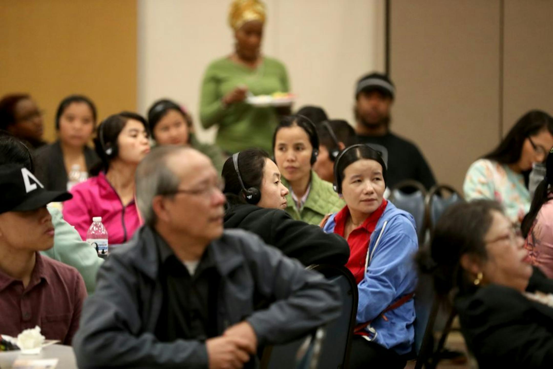 Audience members, some receiving language interpretation in Hmong and Karen, listened to St. Paul mayoral candidates during a forum in April that focused on Hmong concerns.