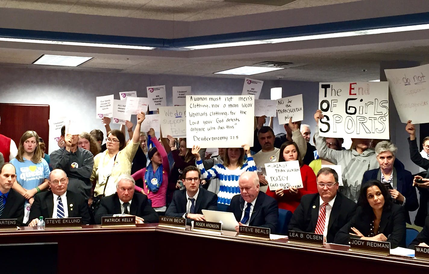 Protestors on both sides of the argument stand behind Minnesota State High School League board members during Thursday's discussion on eligibility policies for transgender athletes. ] Leila Navidi/Star Tribune