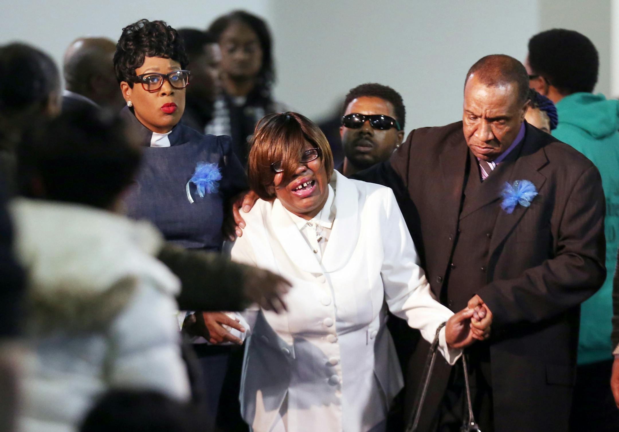 Irma Burns, center, mother of Jamar Clark, is escorted from her son's casket during funeral services at Shiloh Temple International Ministries Wednesday, Nov. 25, 2015 in Minneapolis. A steady stream of mourners entered the north Minneapolis church on Wednesday to pay their respects to Clark, whose death in a confrontation with police sparked more than a week of protests. (Jerry Holt/Star Tribune via AP) MANDATORY CREDIT; ST. PAUL PIONEER PRESS OUT; MAGS OUT; TWIN CITIES LOCAL TELEVISION OUT