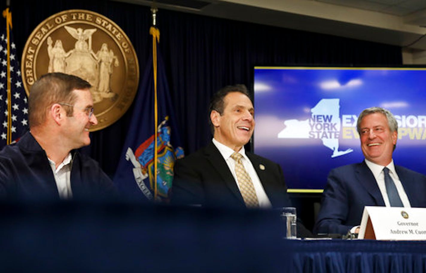 John Schoettler, Amazon vice president for real estate and facilities, left, joins New York Gov. Andrew Cuomo, center, and New York City Mayor Bill de Blasio during a news conference Tuesday Nov. 13, 2018, in New York. Amazon said it will split its much-anticipated second headquarters between New York and northern Virginia. Its New York location will be in the Long Island City neighborhood of Queens. (AP Photo/Bebeto Matthews)