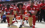 From left, San Francisco 49ers Eli Harold (58), quarterback Colin Kaepernick (7) and Eric Reid (35) kneel during the national anthem before their NFL 