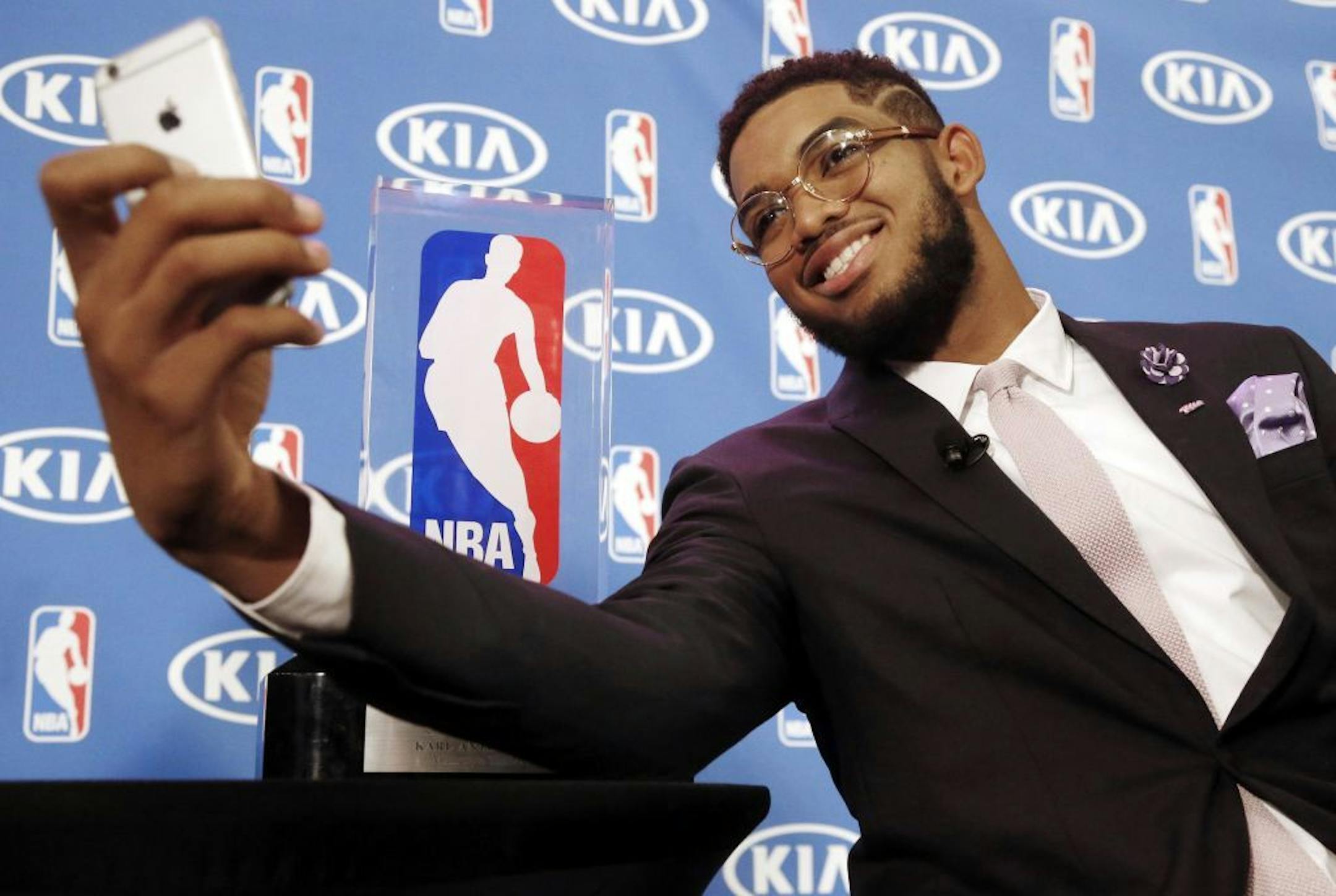 Minnesota Timberwolves' Karl-Anthony Towns takes a selfie with his NBA Rookie of the Year trophy next to him after a news conference announcing his selection Monday, May 16, 2016, in Minneapolis. Towns was the number one overall pick in the 2015 NBA draft.