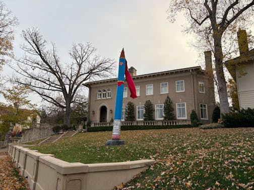 A pencil sculpture dressed up as Superman.