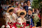 Benjamin Burgos Frias, 8, left, and Boston Burgos Frias, 6, center, get help from their grandmother Becky Cusick, with placing roses on the church alt