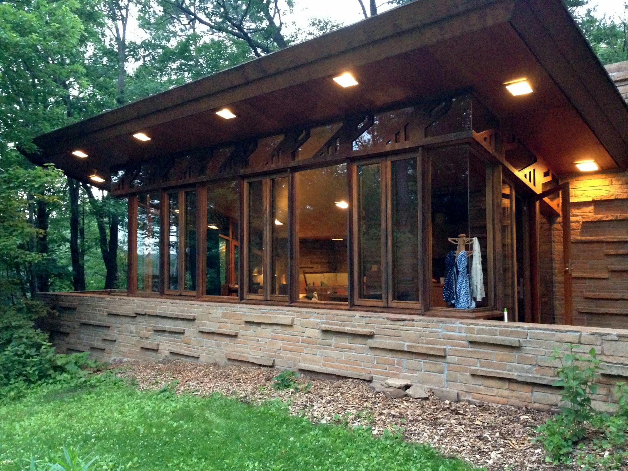 The cottage's flying roof design blends in well with the neighboring bluffs around the lake, and the large wraparound windows pull in the outdoor scenery inside.
