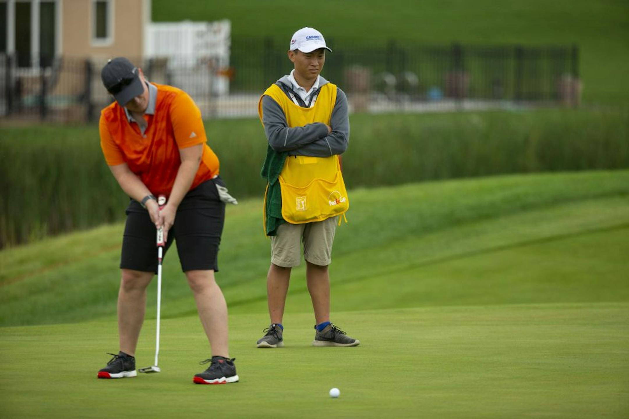Jacob Roy watched Nikki Jung putt while caddying for her during a Pro-Am round on Monday. ALEX KORMANN ¥ alex.kormann@startribune.com Caddie U is a local non-profit that trains and places primarily teenage caddies for work at Twin Cities golf clubs. The program is supported by PGA Tour veteran Tim Herron. Jacob Roy had to work two jobs to support himself the last few years but through caddying and Caddie U, was able to pull himself up and receive a partial scholarship to attend the University of