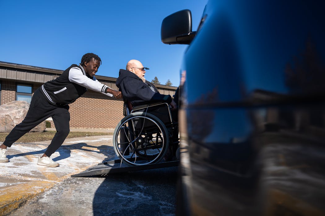 Danny Heskett is pushed up a ramp and into a van by Chris Isaya, employee with Ready to Ride transportation services outside Good Samaritan Society in Albert Lea on Friday, March 1. 