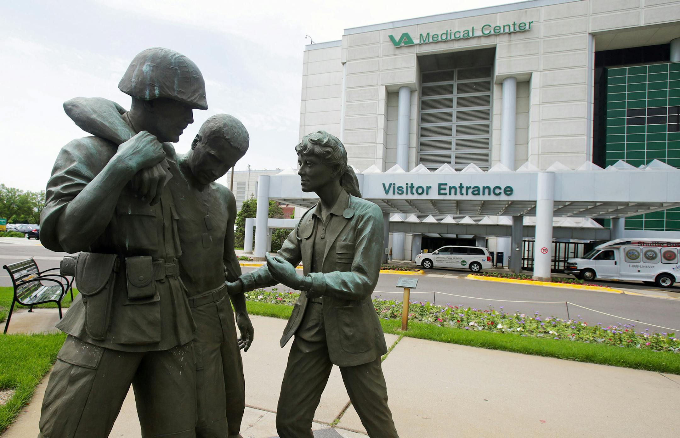FILE - In this June 9, 2014 file photo is a sculpture portraying a wounded soldier being helped on the grounds of the Minneapolis VA Hospital. Minnesota&#xed;s Veterans Affairs clinics and hospitals fare slightly better in delivering timely care to veterans than the national average between September and February, according to six months of appointment data analyzed by the Associated Press. (AP Photo/Jim Mone, File) ORG XMIT: MIN2015051314130372 ORG XMIT: MIN1505131416040110