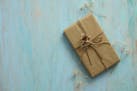 Gift box in recycled paper on wood background