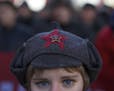 A girl wears a hat with a Soviet-era insignia.