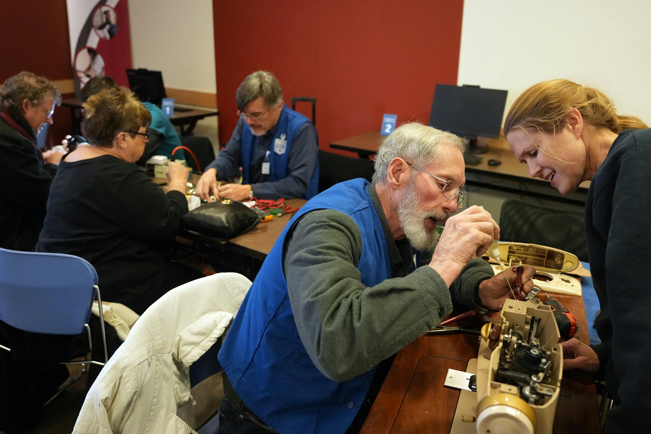 Bonnie Jean Mackay, of St. Paul, watches as Gary Bank lubricates her Singer sewing machine from 1966 during a Ramsey County fix-it clinic Saturday, Nov. 19, 2022 at the Ramsey County Library in Maplewood, Minn