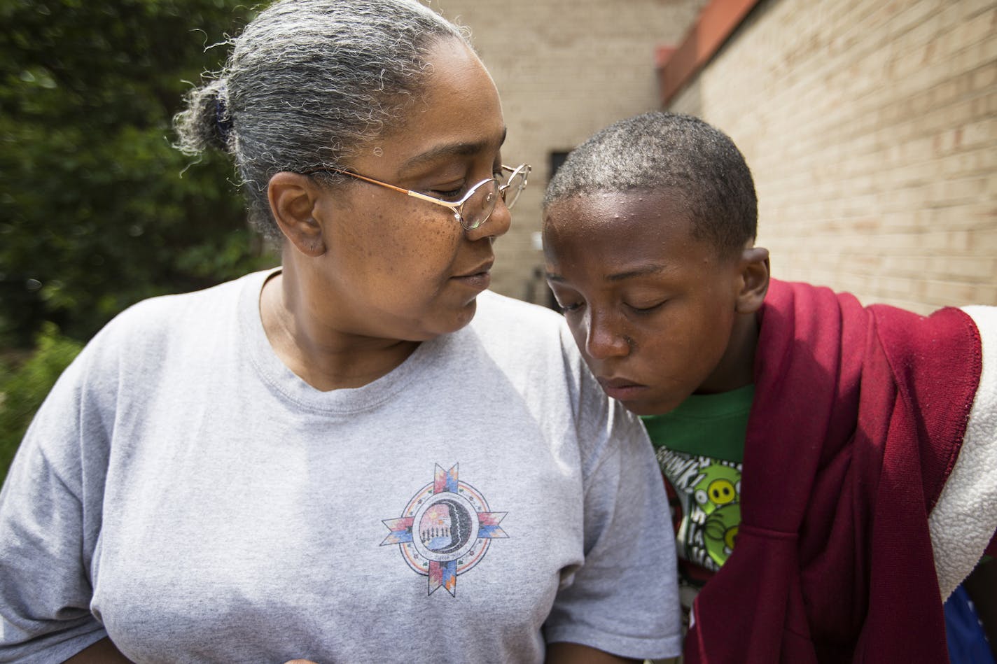 Devont'e Ray-Burns, 12, who has autism and other disabilities, with his mother Charlene Wilford outside their home in St. Paul on Thursday, July 9, 2015. ] LEILA NAVIDI leila.navidi@startribune.com / BACKGROUND INFORMATION: Devont'e Ray-Burns has been helped by a relationship with St. Paul Police officer Rob Zink. The boy, who has autism and other disabilities, is less afraid of police because of Zink's efforts to befriend him. The 45-year-old St. Paul cop has an autistic son and is working with