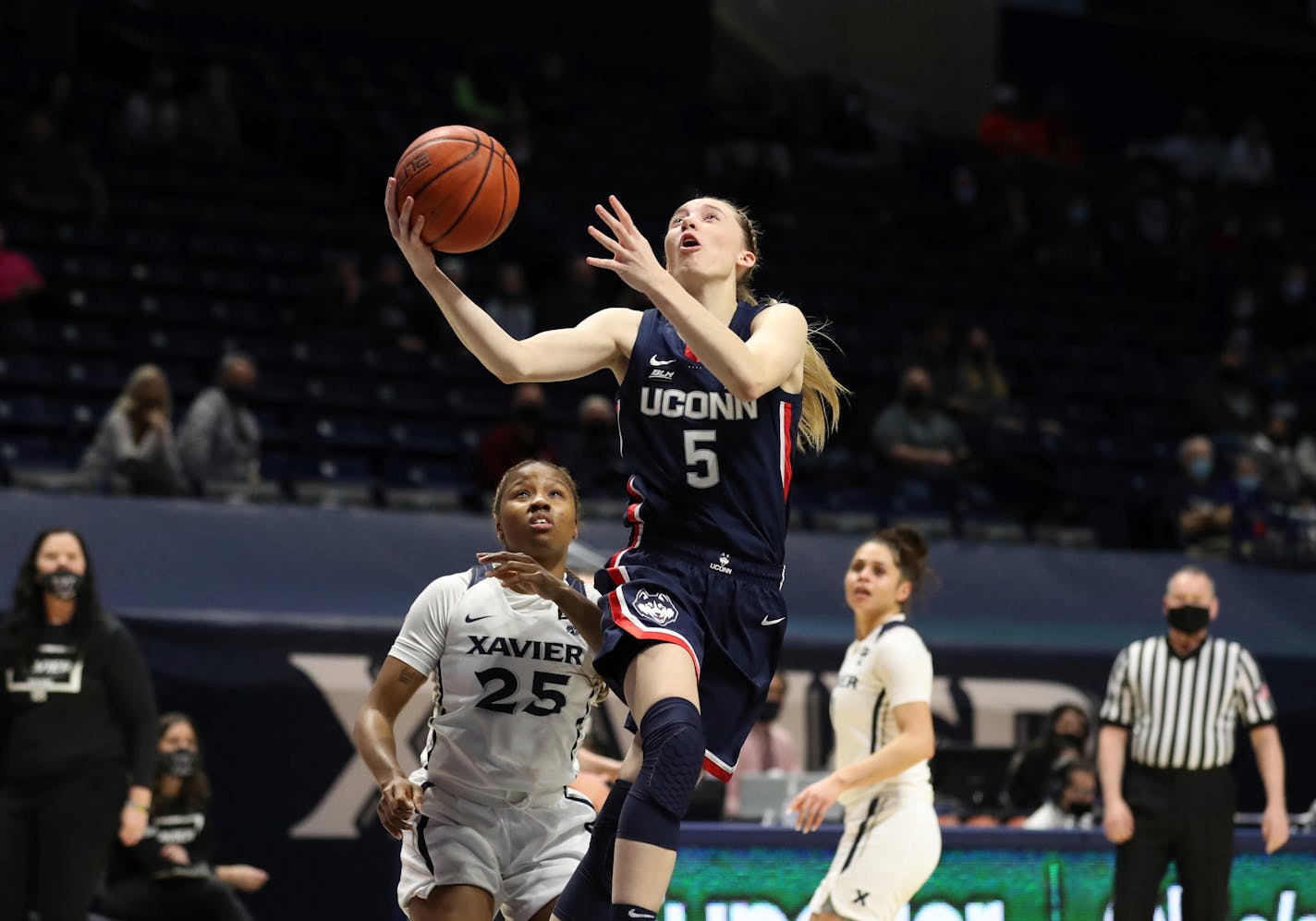 UConn guard Paige Bueckers (5) shoots ahead of Xavier guard Carrie Gross (25) during the first half of an NCAA college basketball game Saturday, Feb. 20, 2021, in Cincinnati. (AP Photo/Gary Landers)