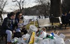 A trash can overflows as people site outside of the Martin Luther King Jr. Memorial by the Tidal Basin, Thursday, Dec. 27, 2018, in Washington, during
