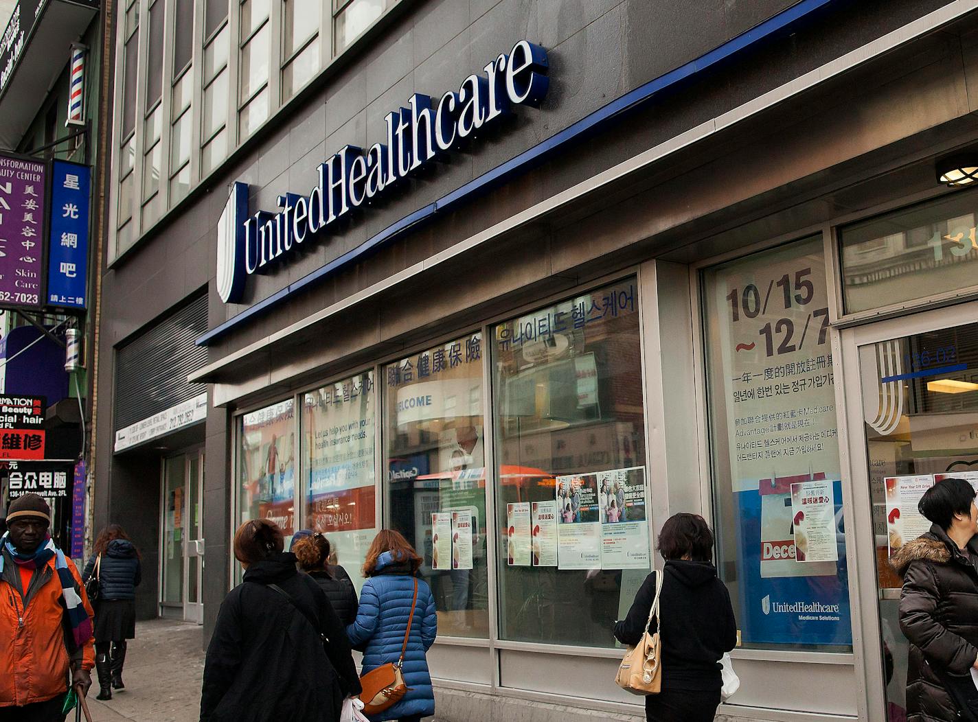 Pedestrians pass in front of a UnitedHealthcare store in the Queens borough of New York, U.S., on Monday, Jan. 14, 2013. The experiment to sell health insurance to consumers in retail stores by UnitedHealth Group Inc., the biggest U.S. medical insurer, is designed to help the company compete in anticipation of sweeping changes under the new health-care law. Photographer: Michael Nagle/Bloomberg