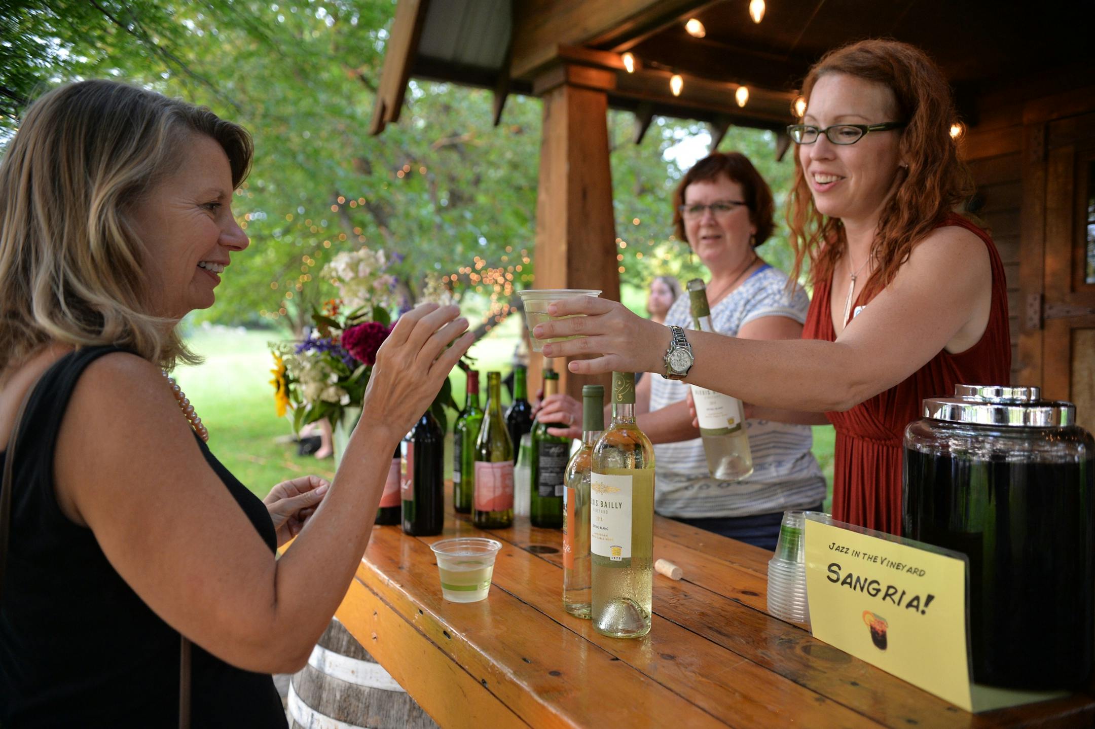 Climate Generation volunteer, Aimee Jaroscak pours a glass of white wine for former Minnesota State Representative Ellen Anderson during Wine & Dine for Climate at Alexis Bailly Vineyard in Hastings.