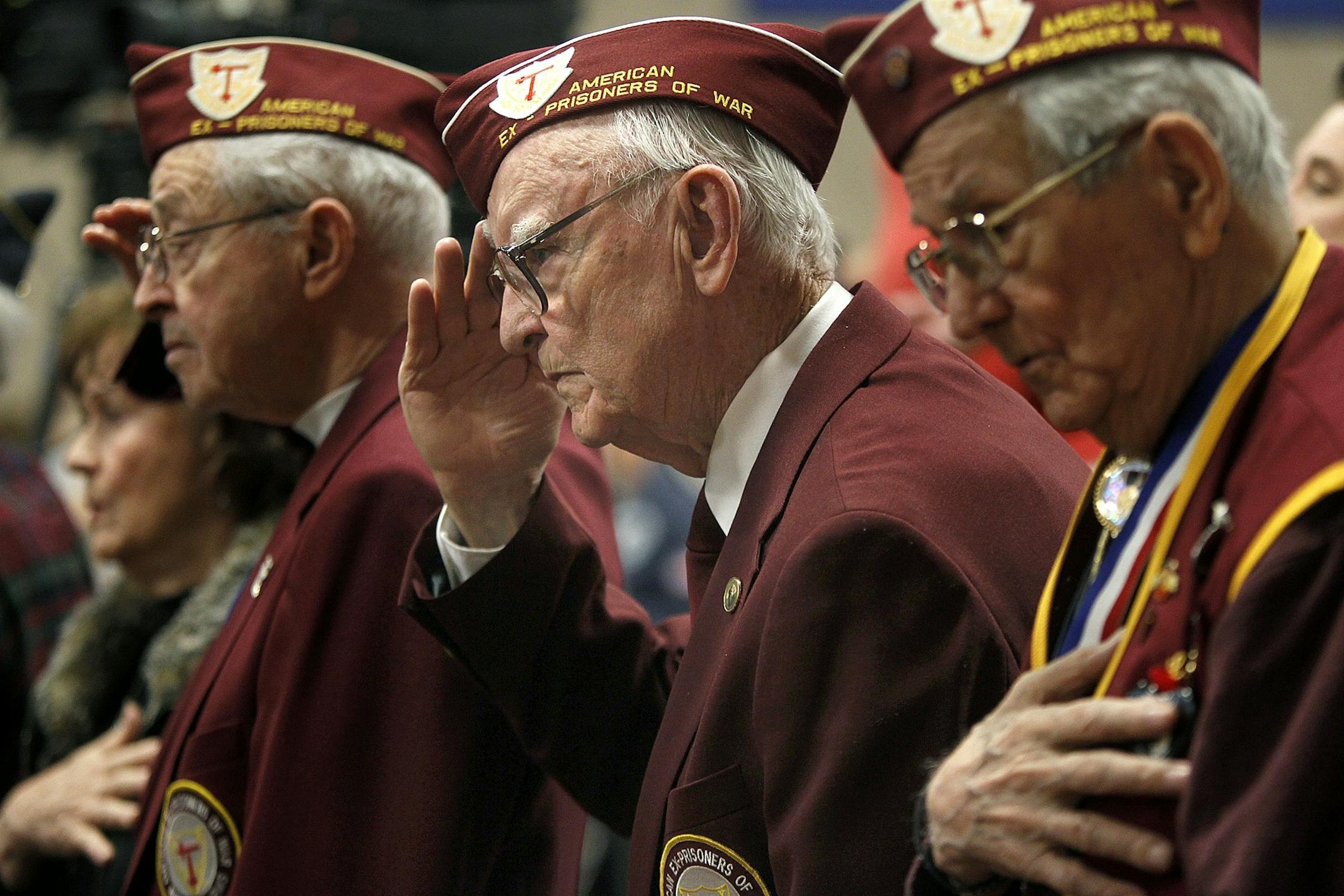 Former prisoners of war, from left, Harold Brick, Richard Carroll and LeRoy Shaw honored the posting of the colors at the state's Veterans Day observance at the Veterans Memorial Community Center in Inver Grove Heights on Sunday.