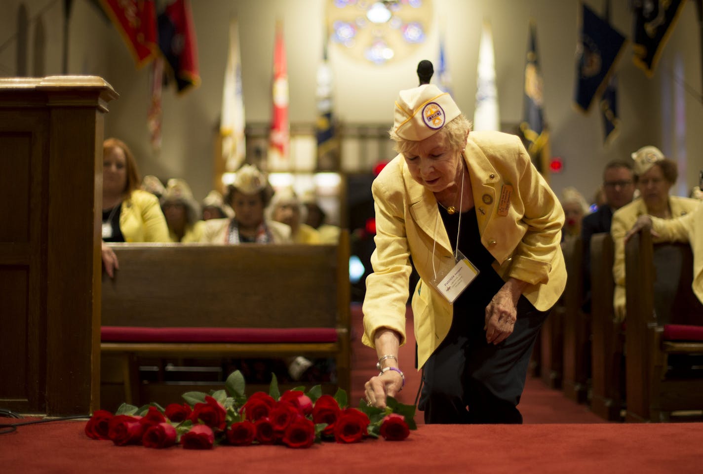 Patti Sampers places a rose on the steps of the altar in honor of her late husband, Chief Petty Officer James W. Sampers.