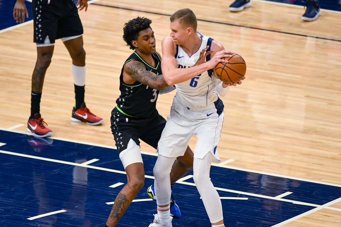 Minnesota Timberwolves forward Jaden McDaniels (3) tries to slap the ball away from Dallas Mavericks center Kristaps Porzingis&nbsp;during the first half of an NBA basketball game Wednesday, March 24, 2021, in Minneapolis. (AP Photo/Craig Lassig)