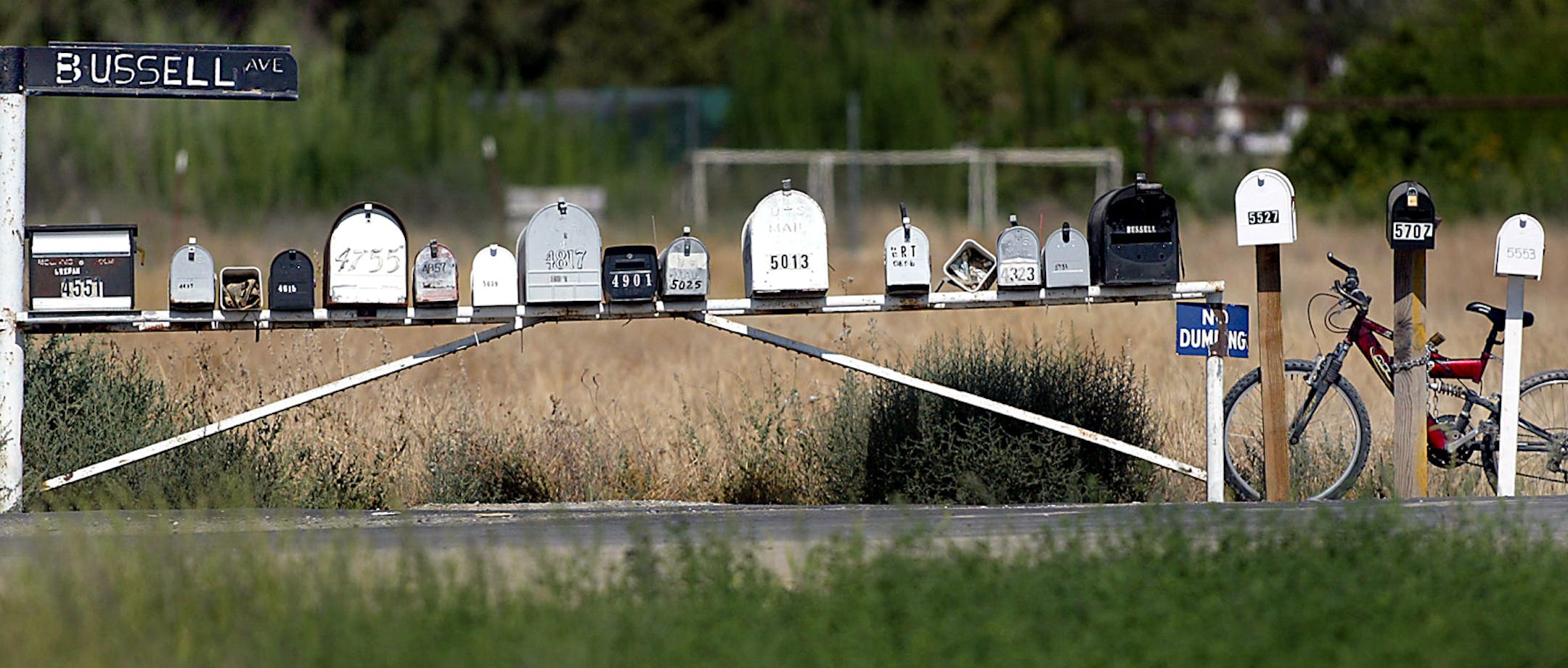 A bicycle is chained to a mailbox in a long row of mailboxes on Bussell Avenue northwest of Bakersfield, Calif., Friday, July 8, 2005. (AP Photo/The Bakersfield Califorian, Casey Christie) ORG XMIT: CABAK102