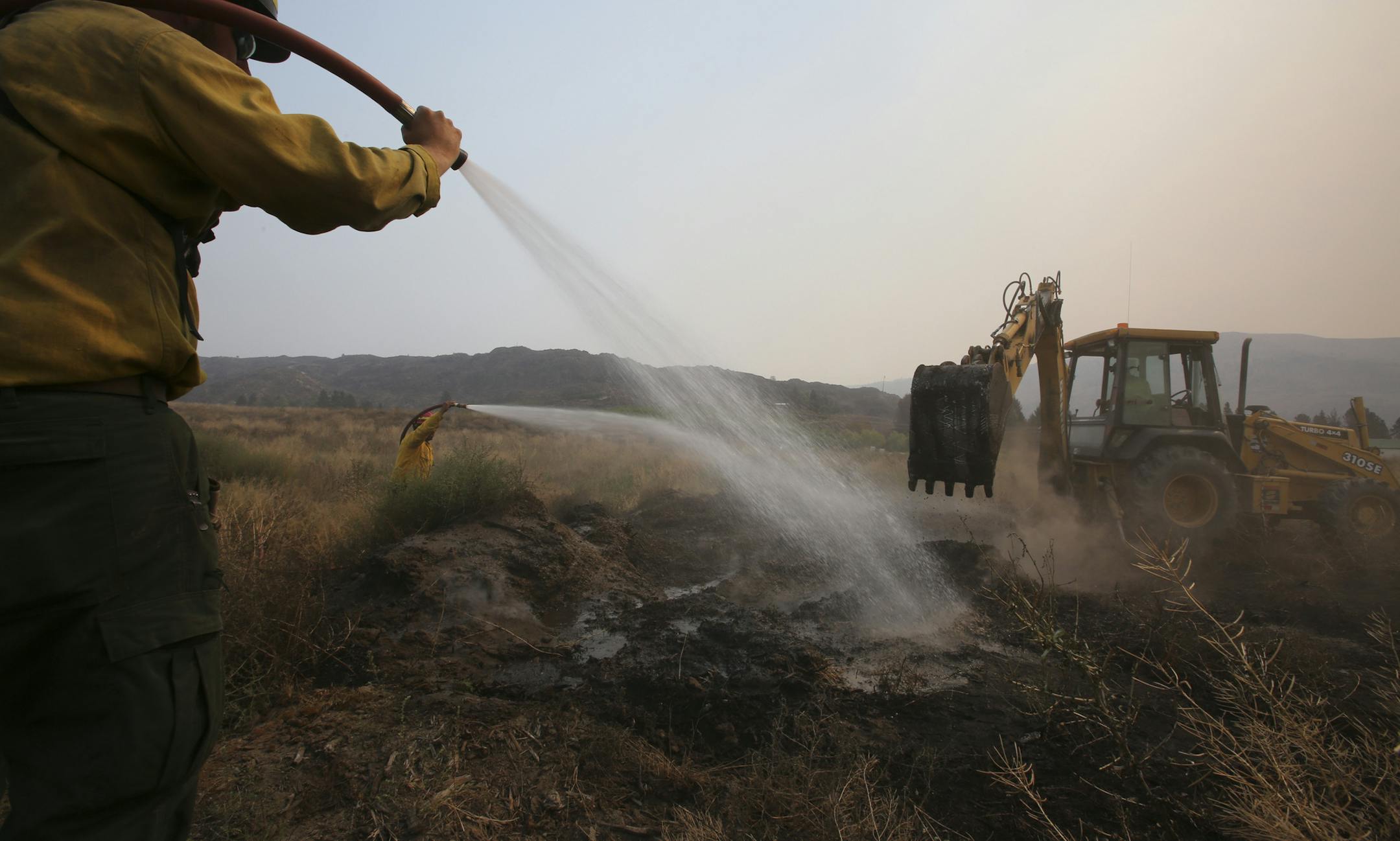 Contractor firefighters douse a smoldering area to prevent flare-ups near Chelan, Wash., Aug. 20, 2015. More acres have burned so far this year — approximately 7.2 million by Thursday — than in each of the previous 10 years, according to statistics compiled by the National Interagency Fire Center. (Ruth Fremson/The New York Times)