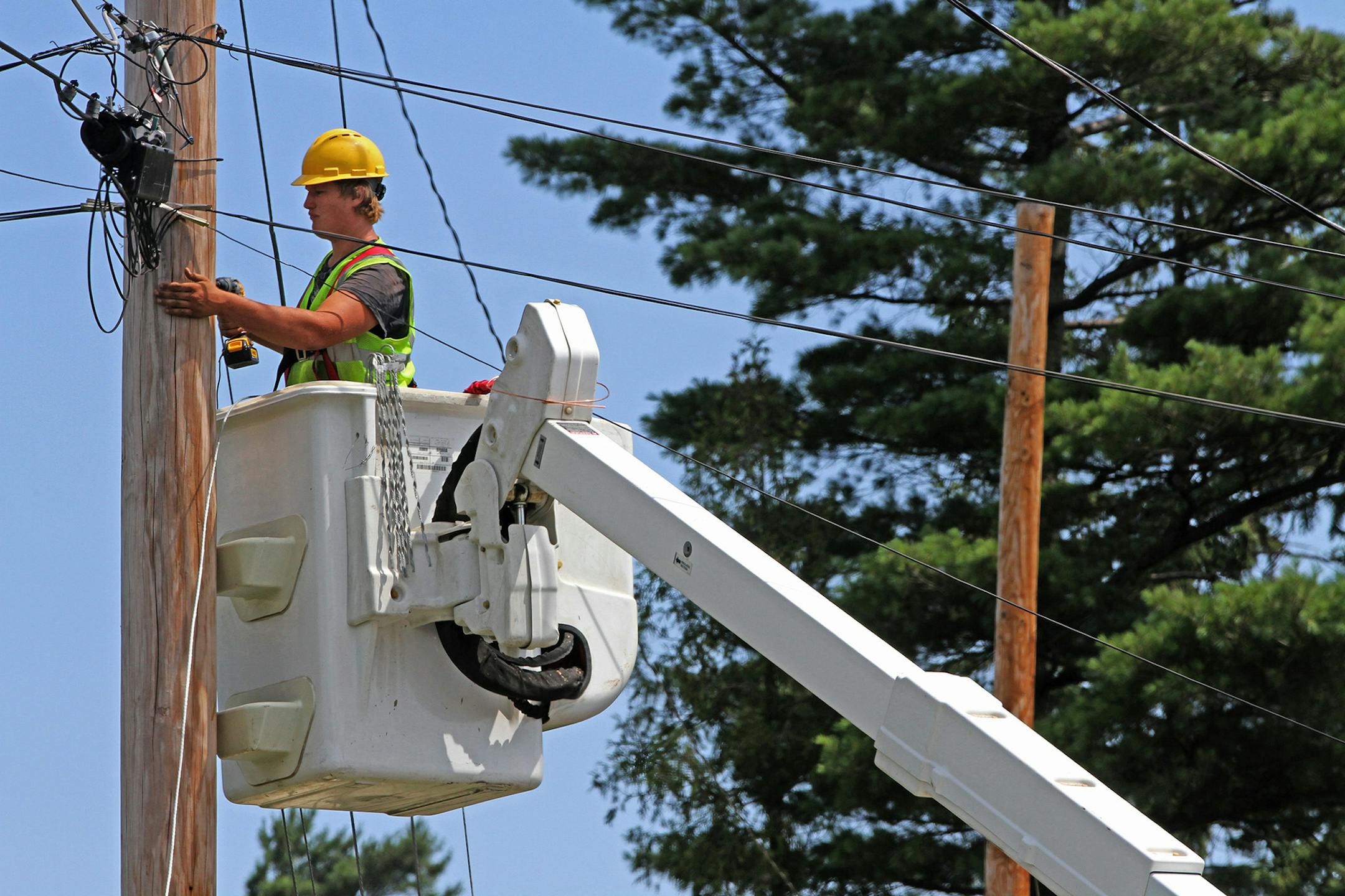 Seth Kern, with Lake States Construction, a sub-contractor of Lake Connections, readied telephone poles in Two Harbors to string stainless steel strand cables from which fiber optic cable will be lashed to on 7/31/12. By the time the communications project is done in 2014 around 2000 miles of fiber optic cable will be strung, connecting customers with broadband internet, video and telephone service. ] Bruce Bisping/Star Tribune bbisping@startribune.com ORG XMIT: MIN2014022618253324