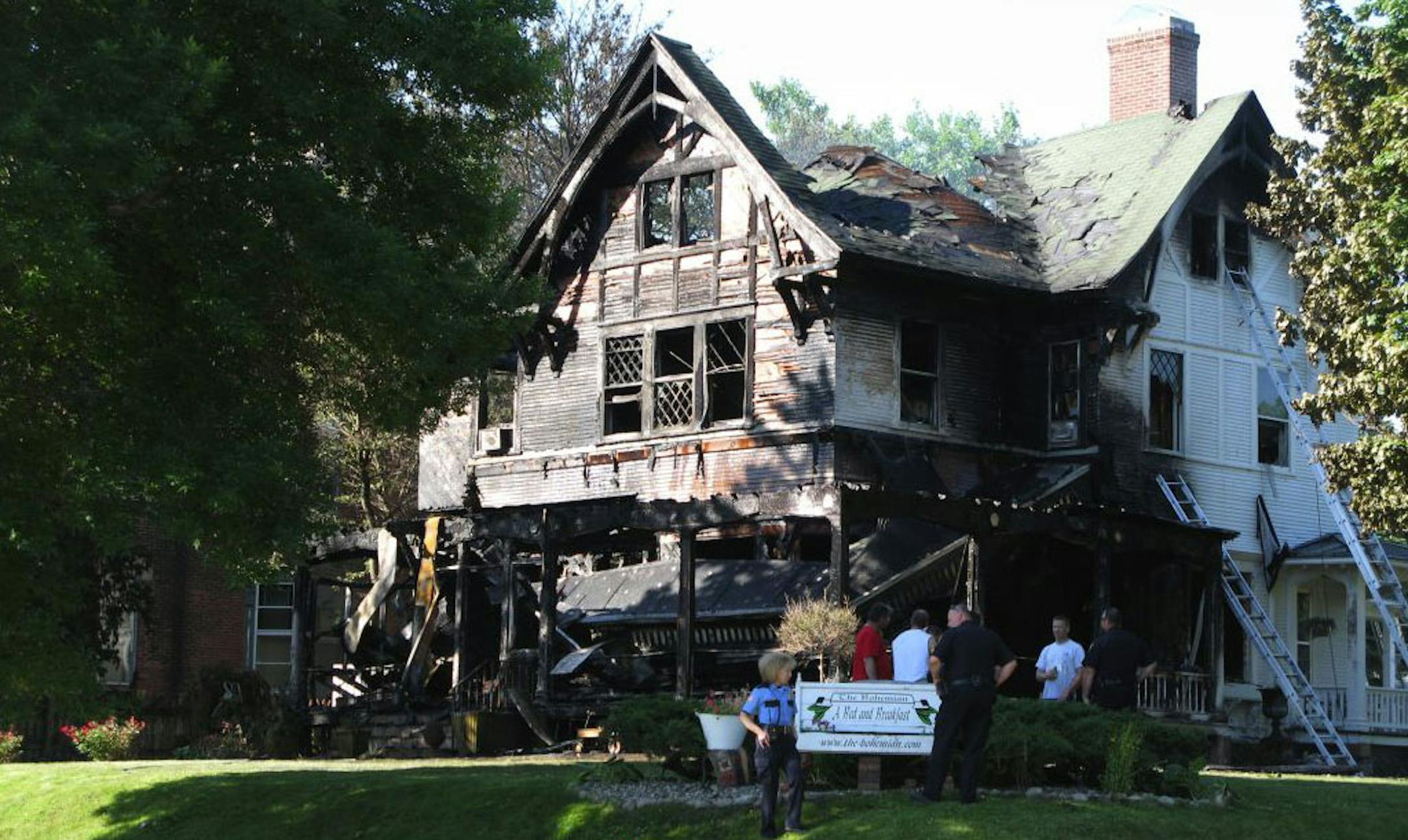 New Ulm police and fire department officials stand outside the Bohemian Bed & Breakfast, on Saturday, July 2, 2011.