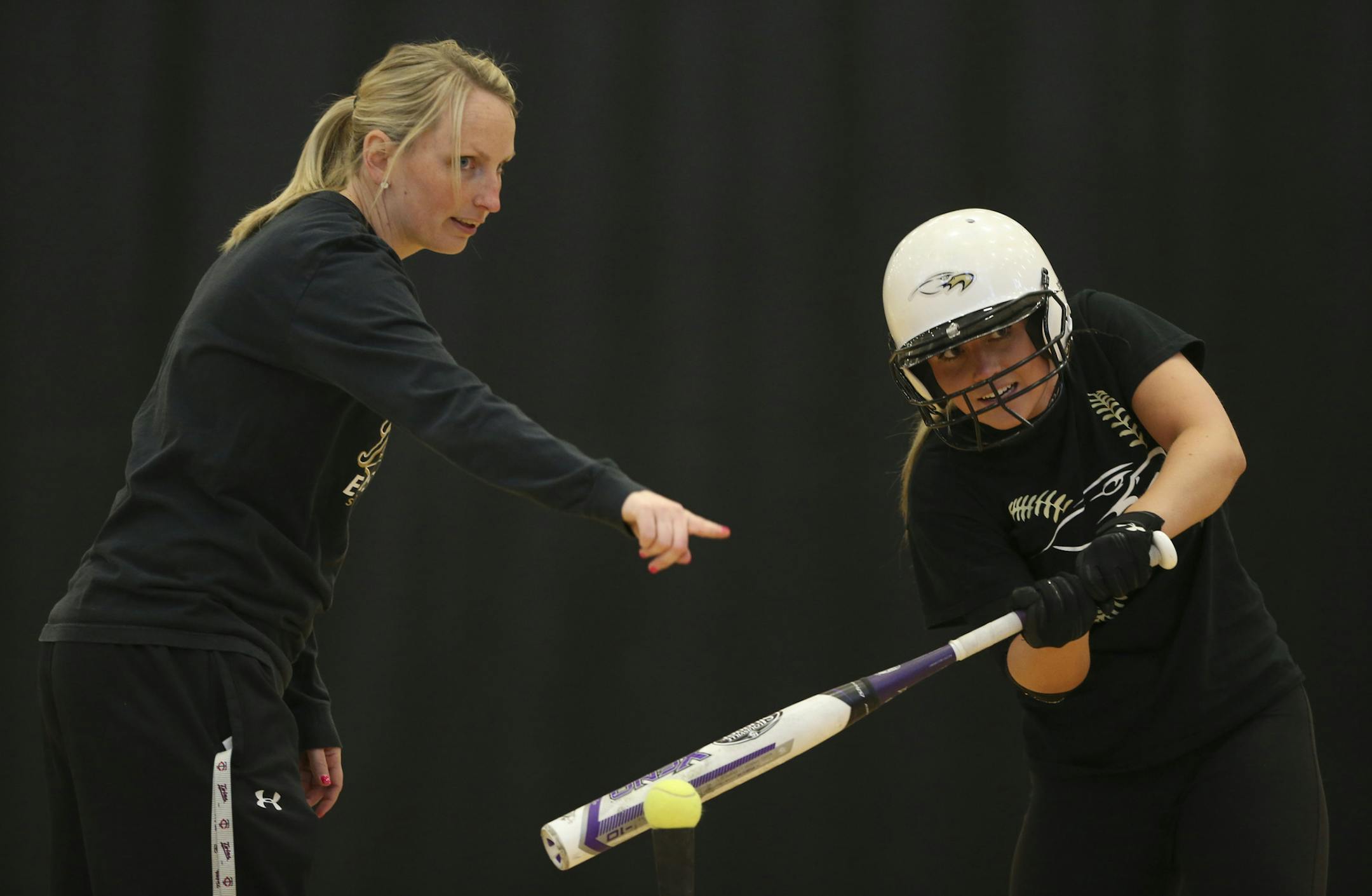East Ridge head softball coach Afton Murray worked with Makaela Egan at a batting tee in the gym at East Ridge High School Tuesday afternoon. ] JEFF WHEELER ï jeff.wheeler@startribune.com The East Ridge High School softball team practiced in the gym after school Tuesday afternoon, March 24, 2015.
